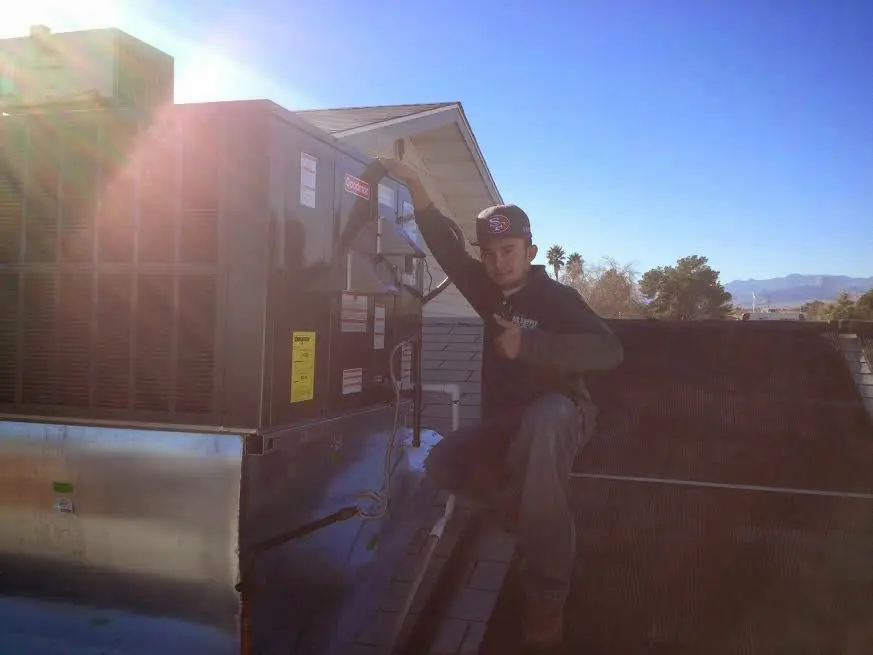 HVAC technician performing Heat Pump Repair on a rooftop unit in Braddock